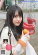 A young woman holding an orange on a swing.