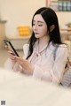 A woman sitting on a couch looking at her phone.